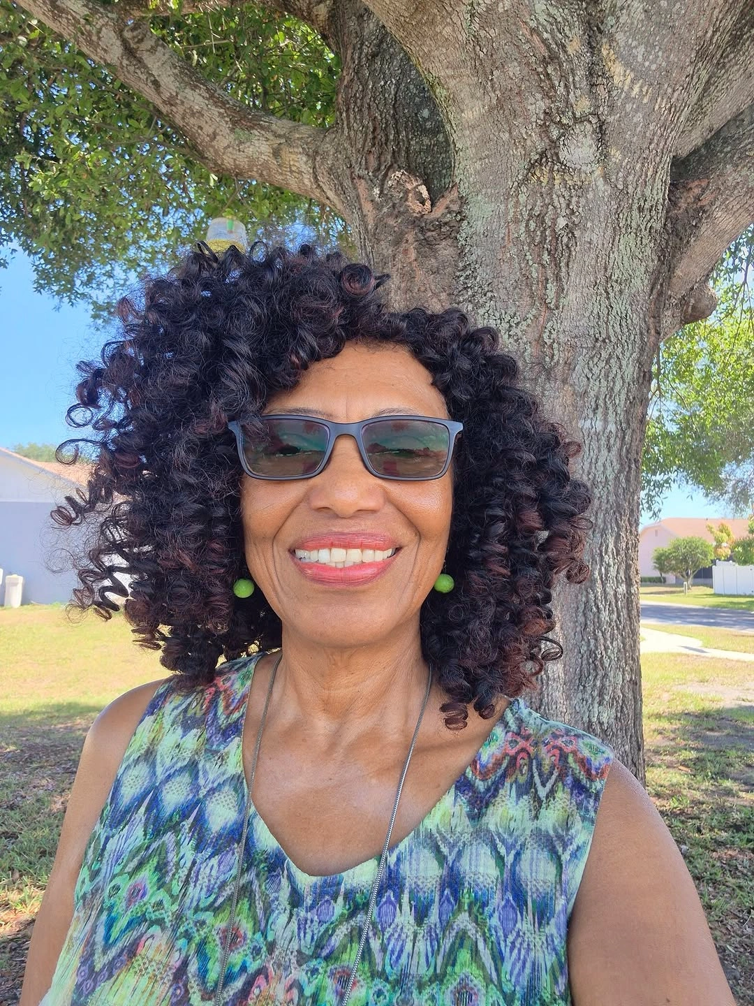 Short-to-medium dark curls with rounded volume and glasses