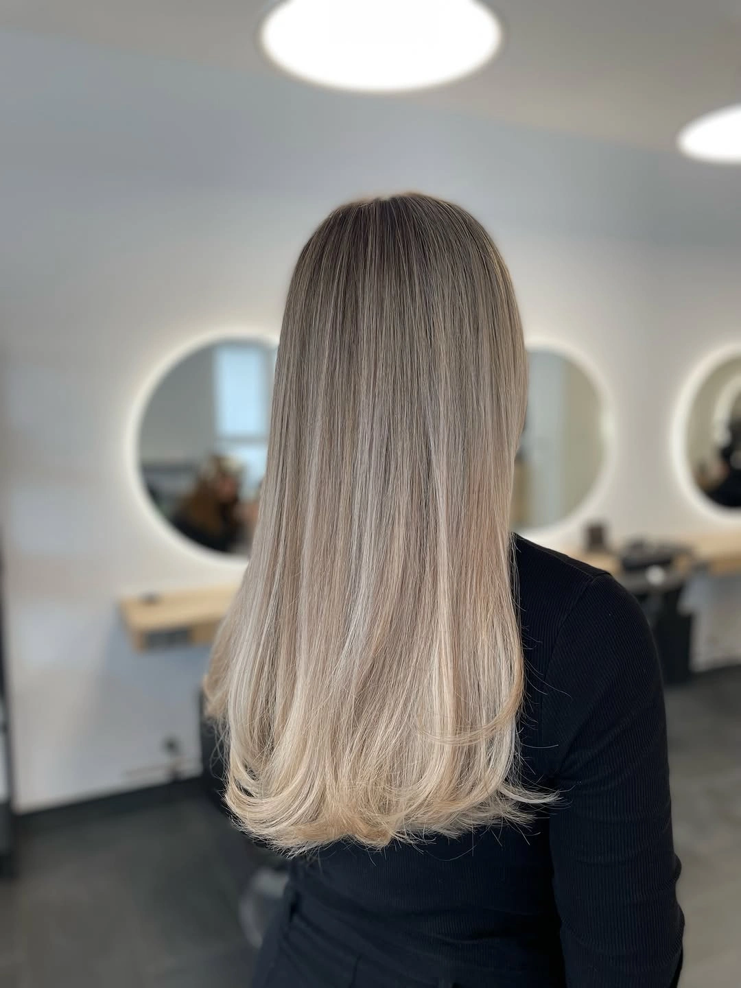 Medium-long ash blonde hair with smooth rounded lower finish