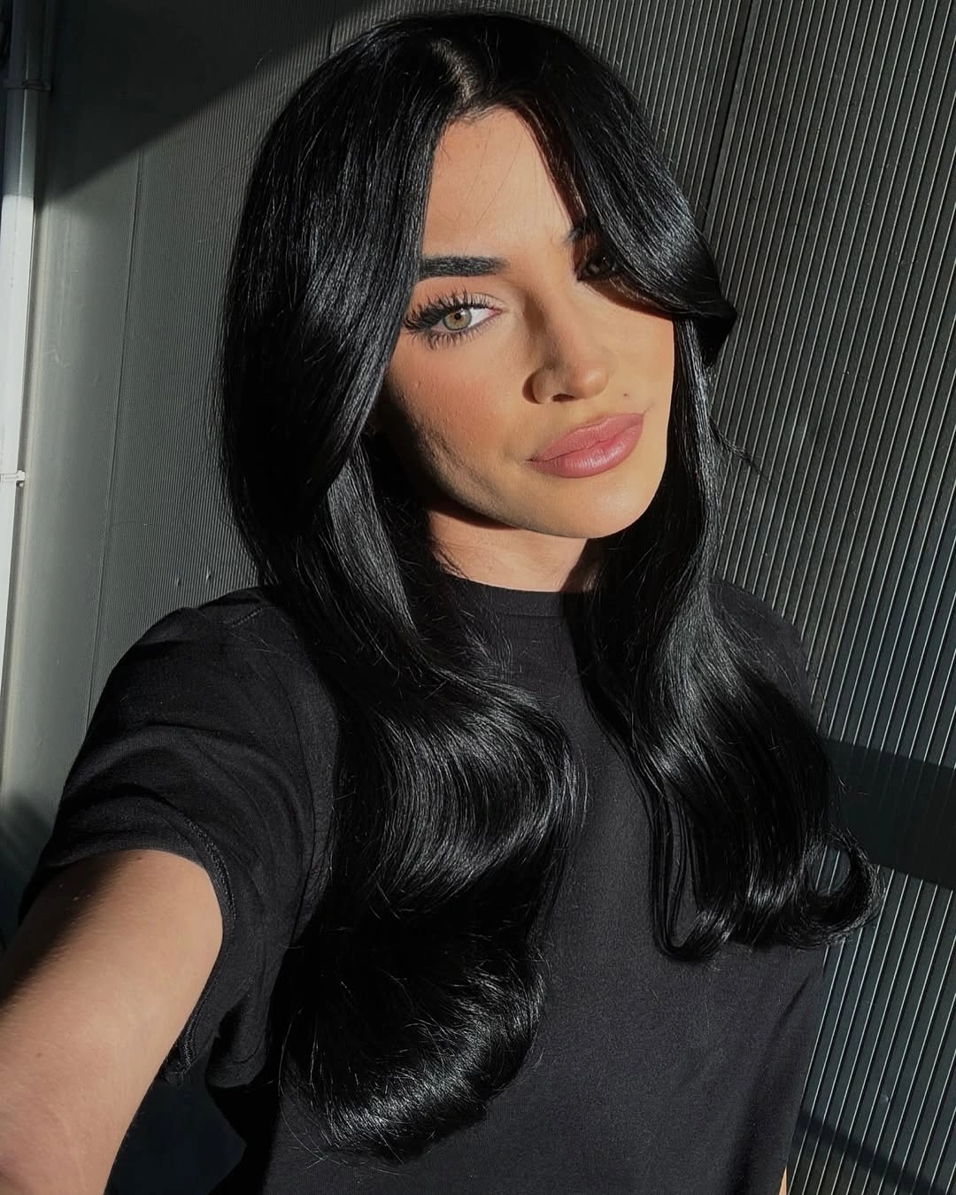 Medium-long glossy black hair with large low-set waves