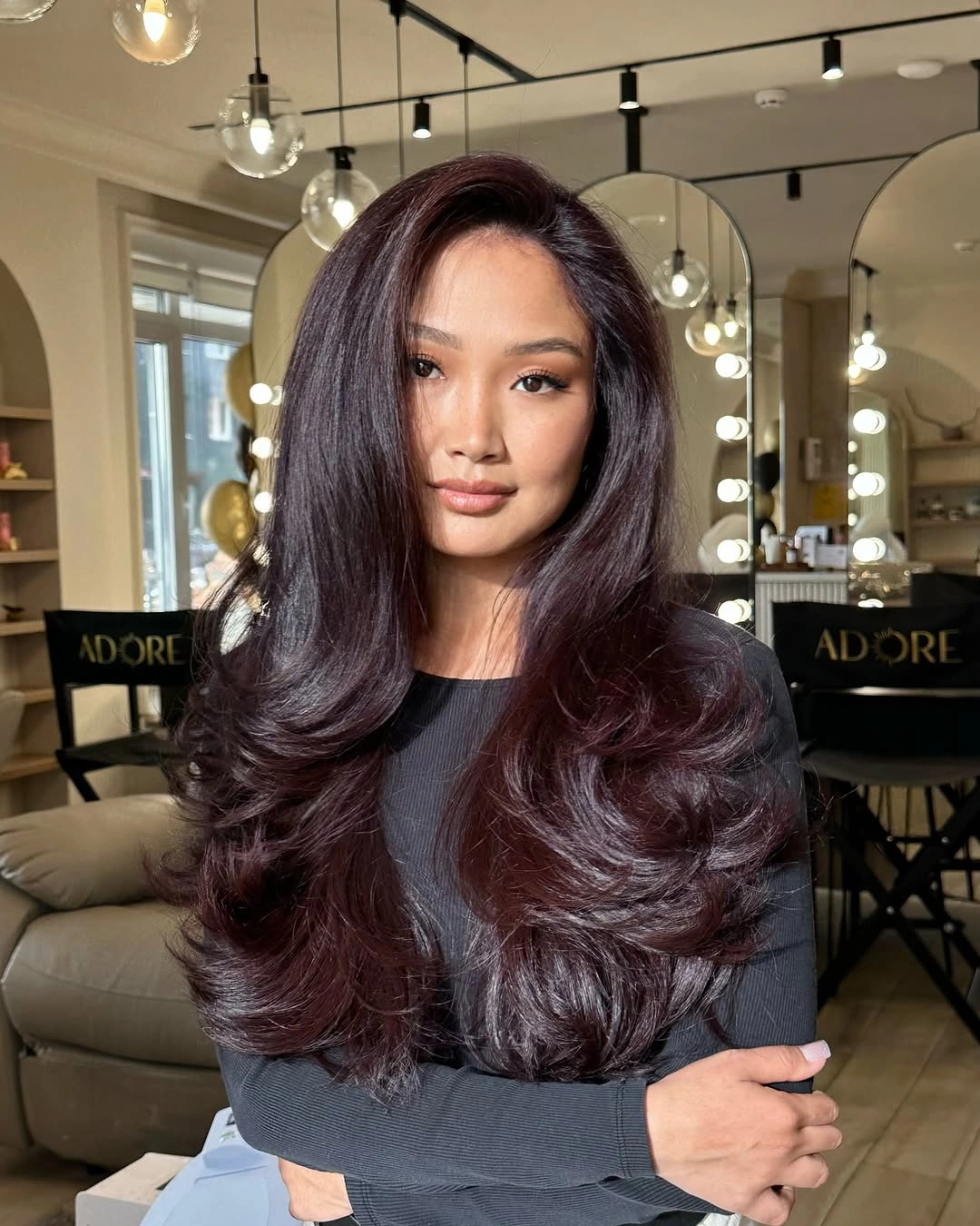 Medium-long burgundy brown hair with side part and large curls