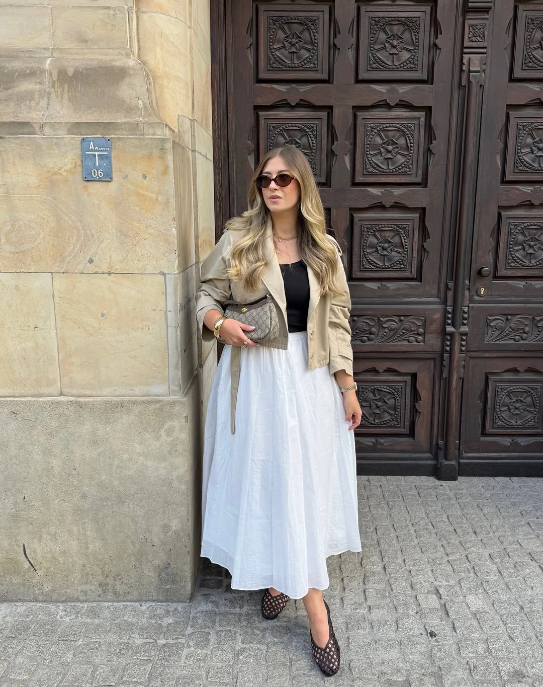 Taupe cropped jacket with black top and white midi skirt