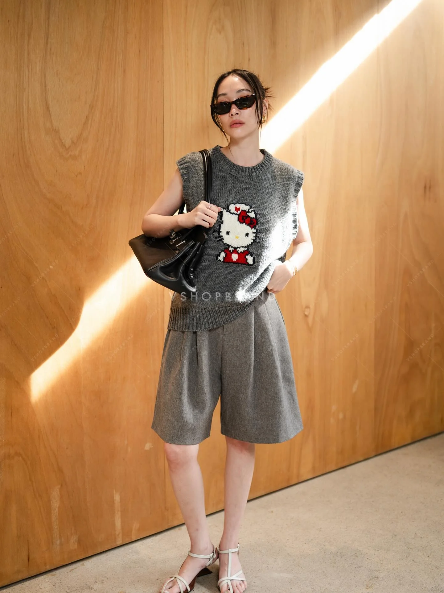 Gray vest with cartoon graphic, pleated shorts and sandals