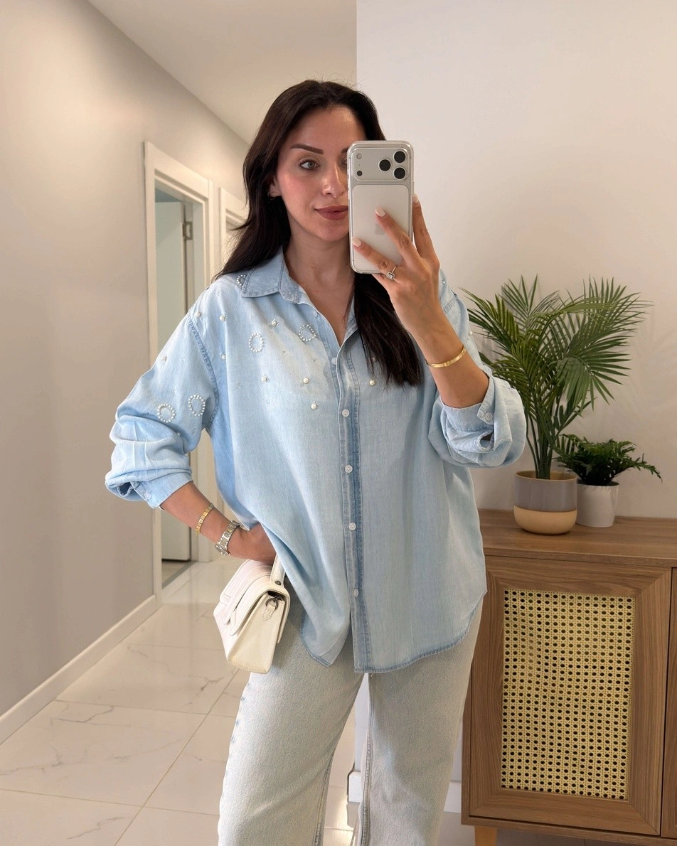 Light blue button-down shirt with white pants and bag