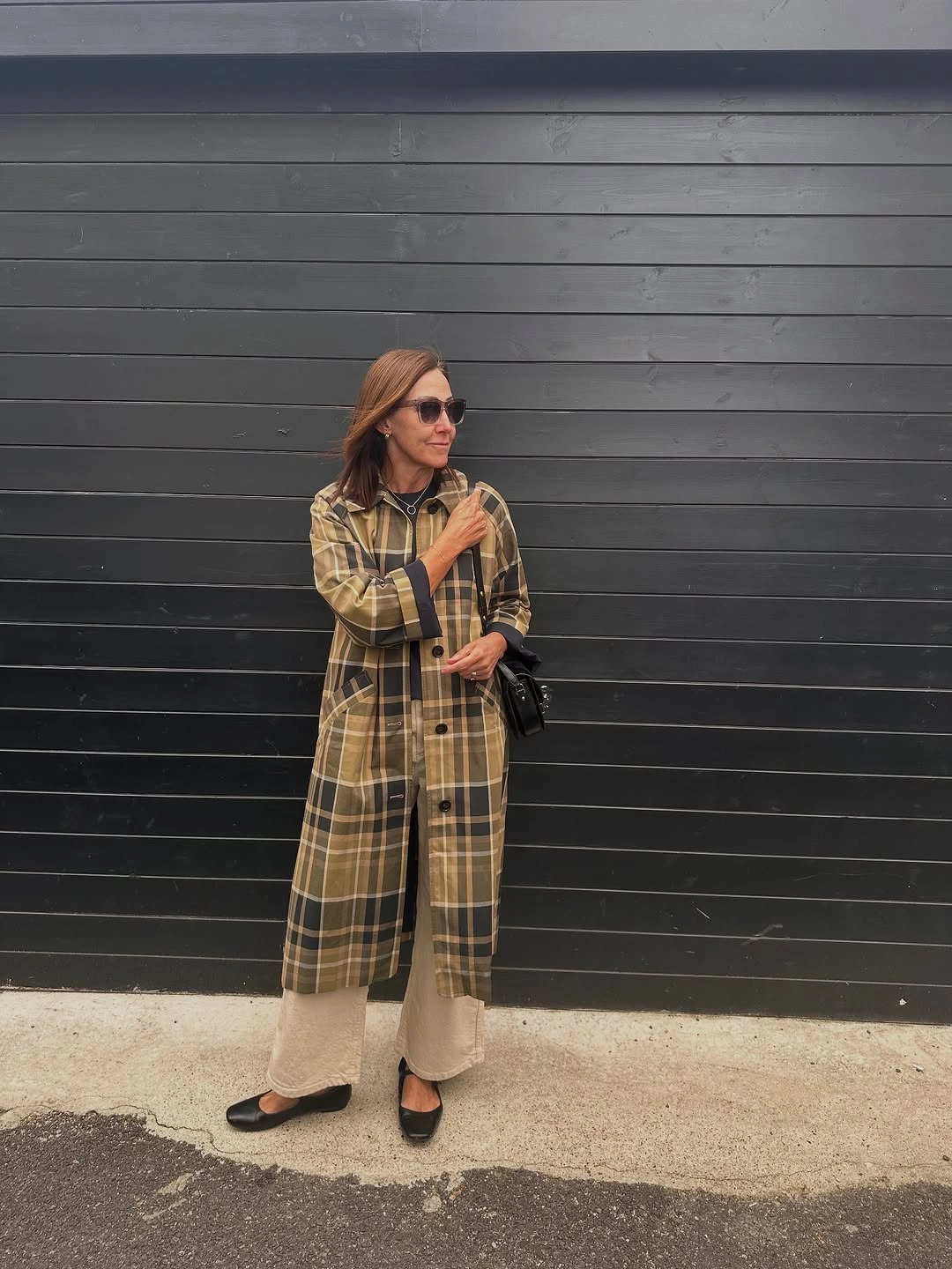 Woman in long checked layer beige pants and black flats