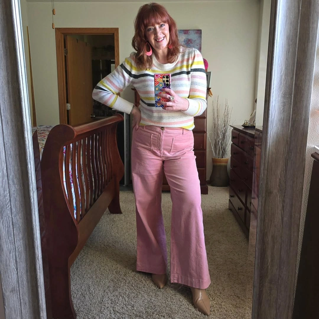 Woman in striped sweater pink pants and tan pointed shoes