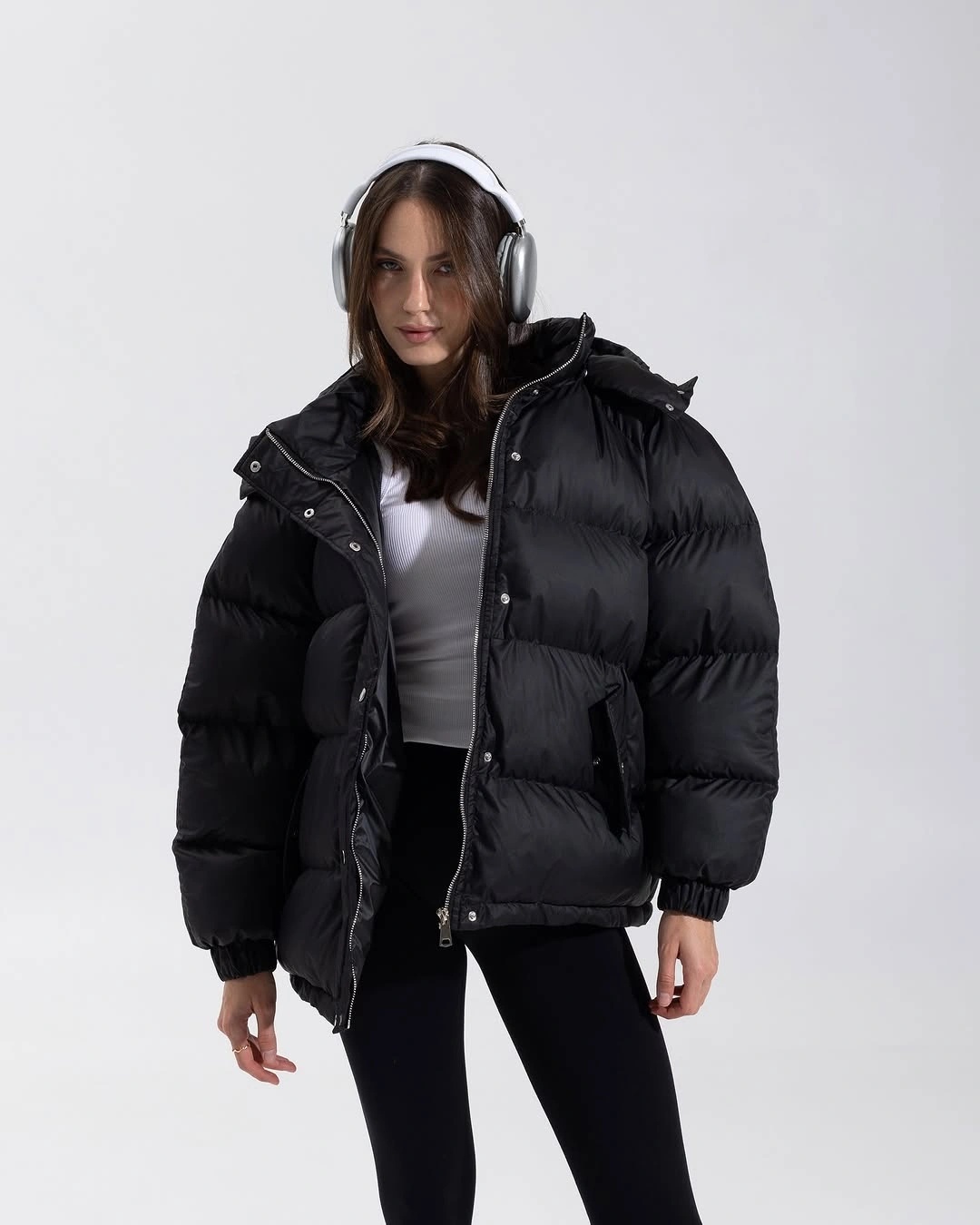 Black puffer over white top with leggings and headphones