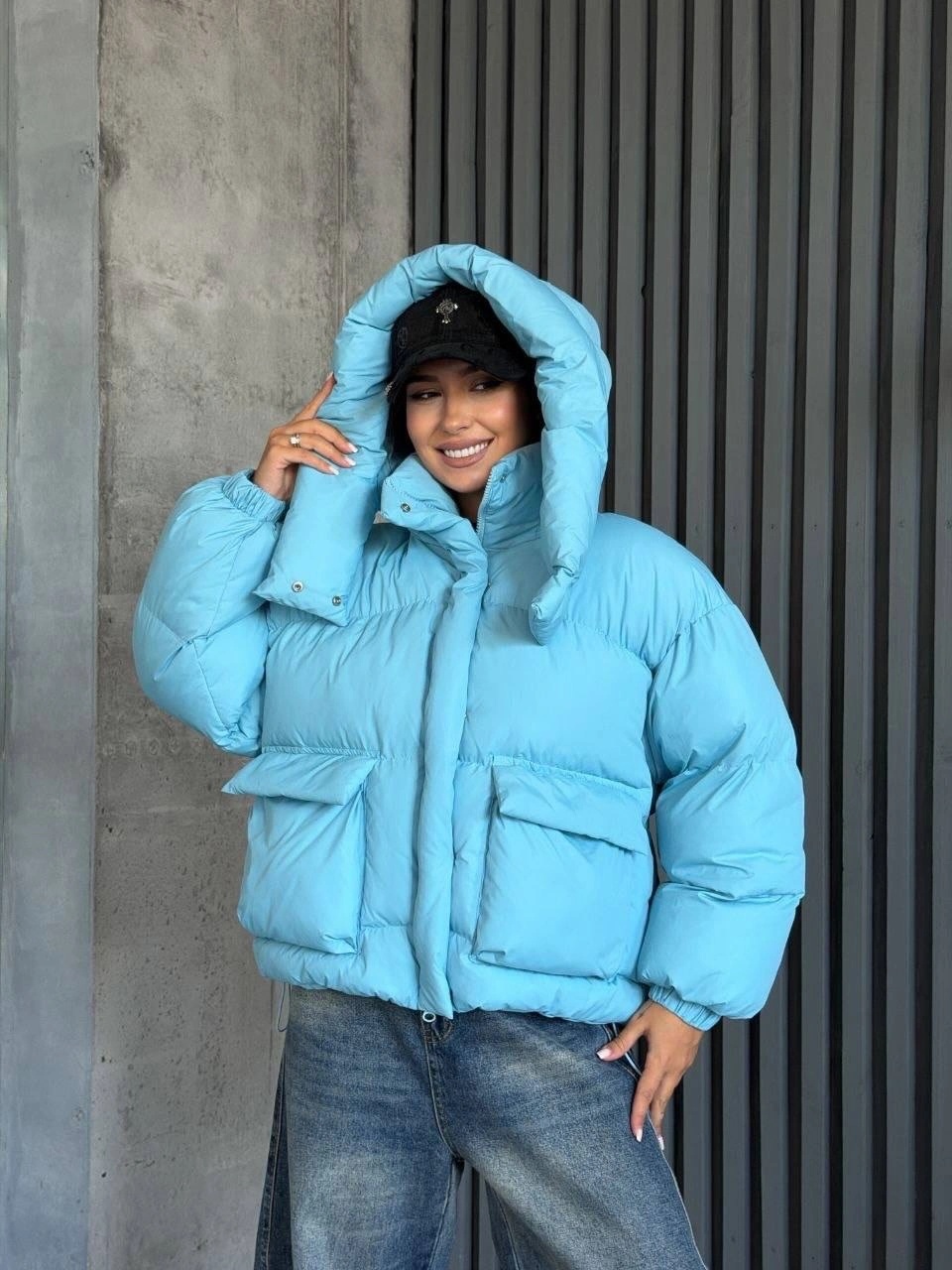Bright blue cropped puffer with black beanie and jeans