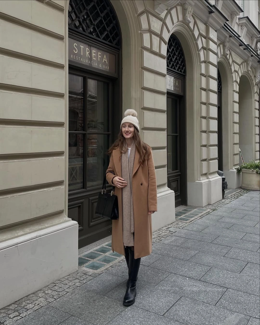 Camel long coat over light dress with black boots