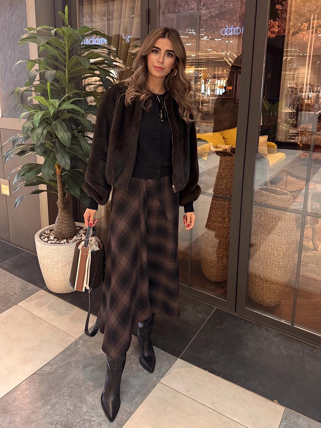 Brown jacket with long plaid skirt and pointed black boots