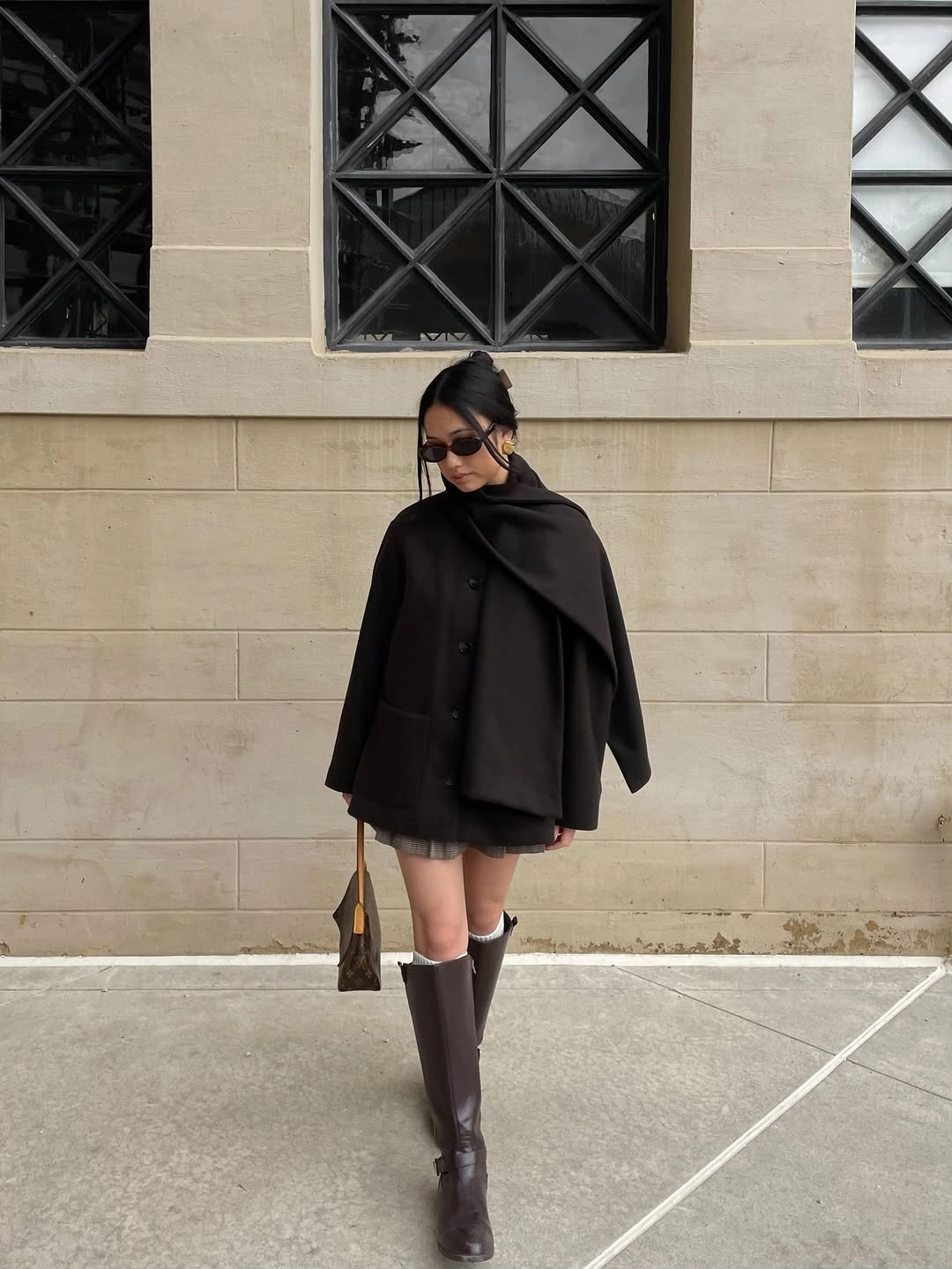 Black cape with short pleated gray hem and tall boots