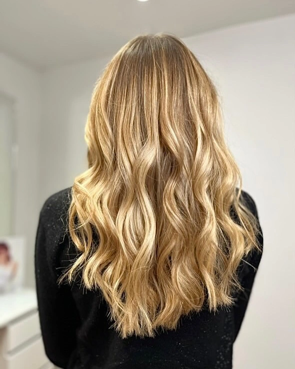 Long golden blonde hair with loose waves and dimensional shine