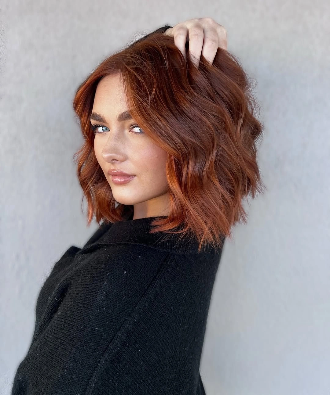 Short copper red wavy bob with side part and soft texture