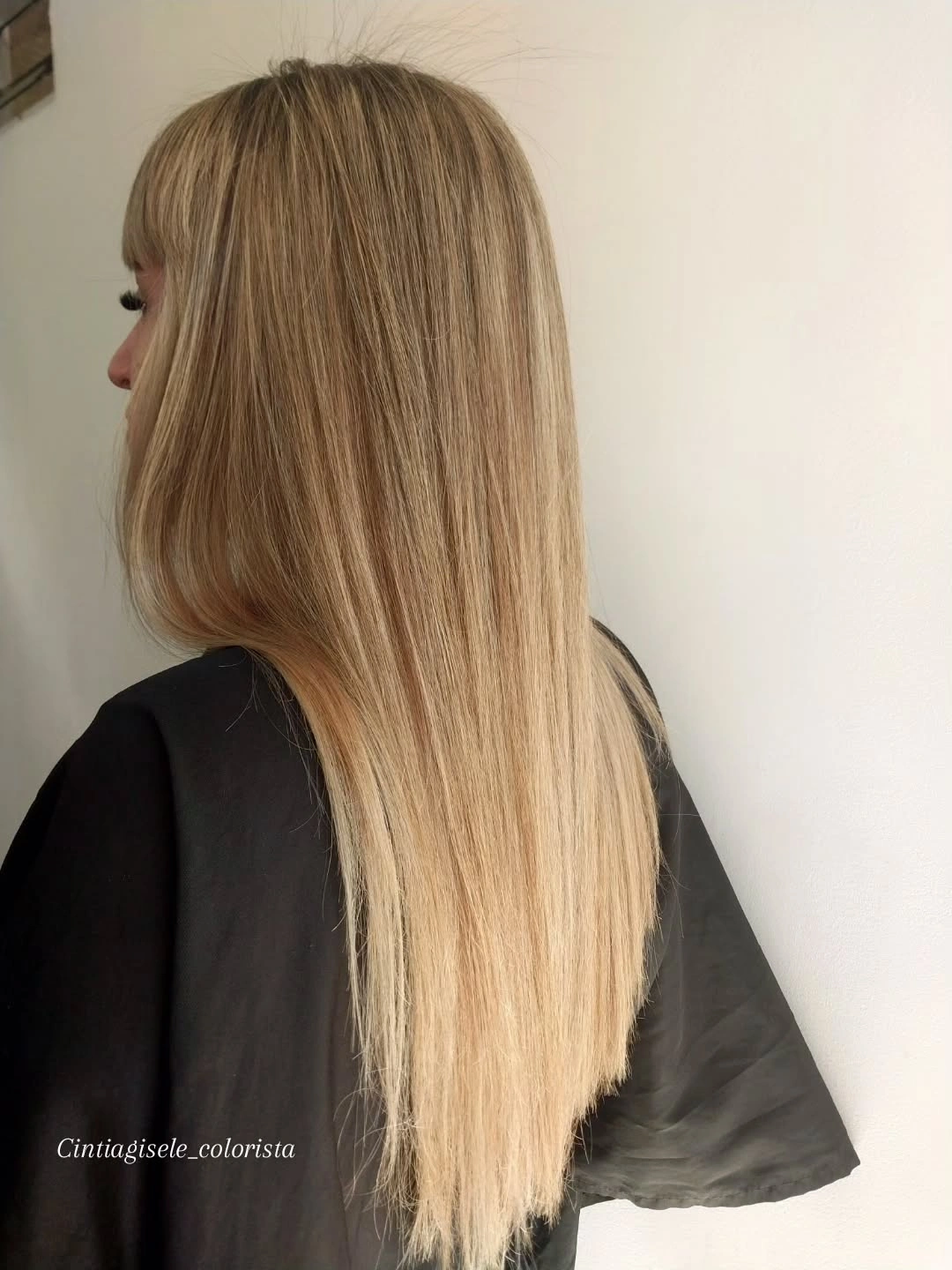 Long honey-beige blonde hair with full bangs and lighter strands