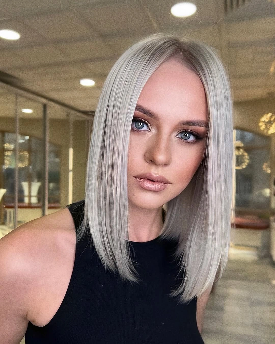 Shoulder-length silver-gray blonde hair with subtly darker roots