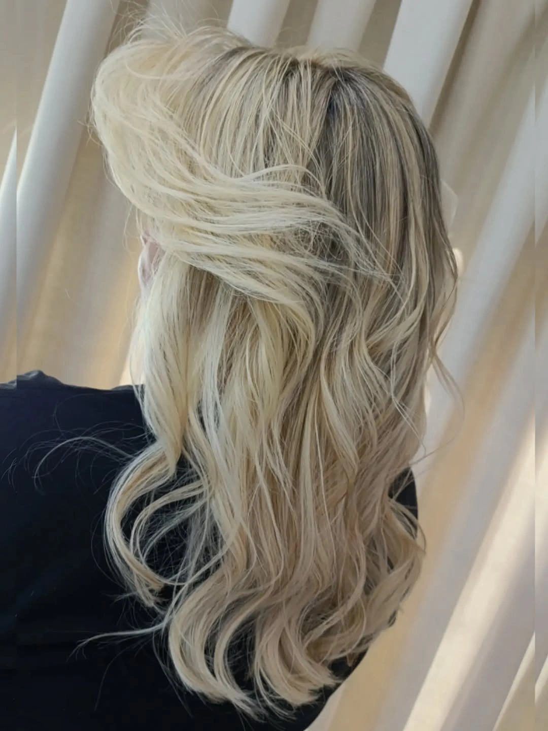 Wavy blonde hair with ash-beige roots and pale creamy ends