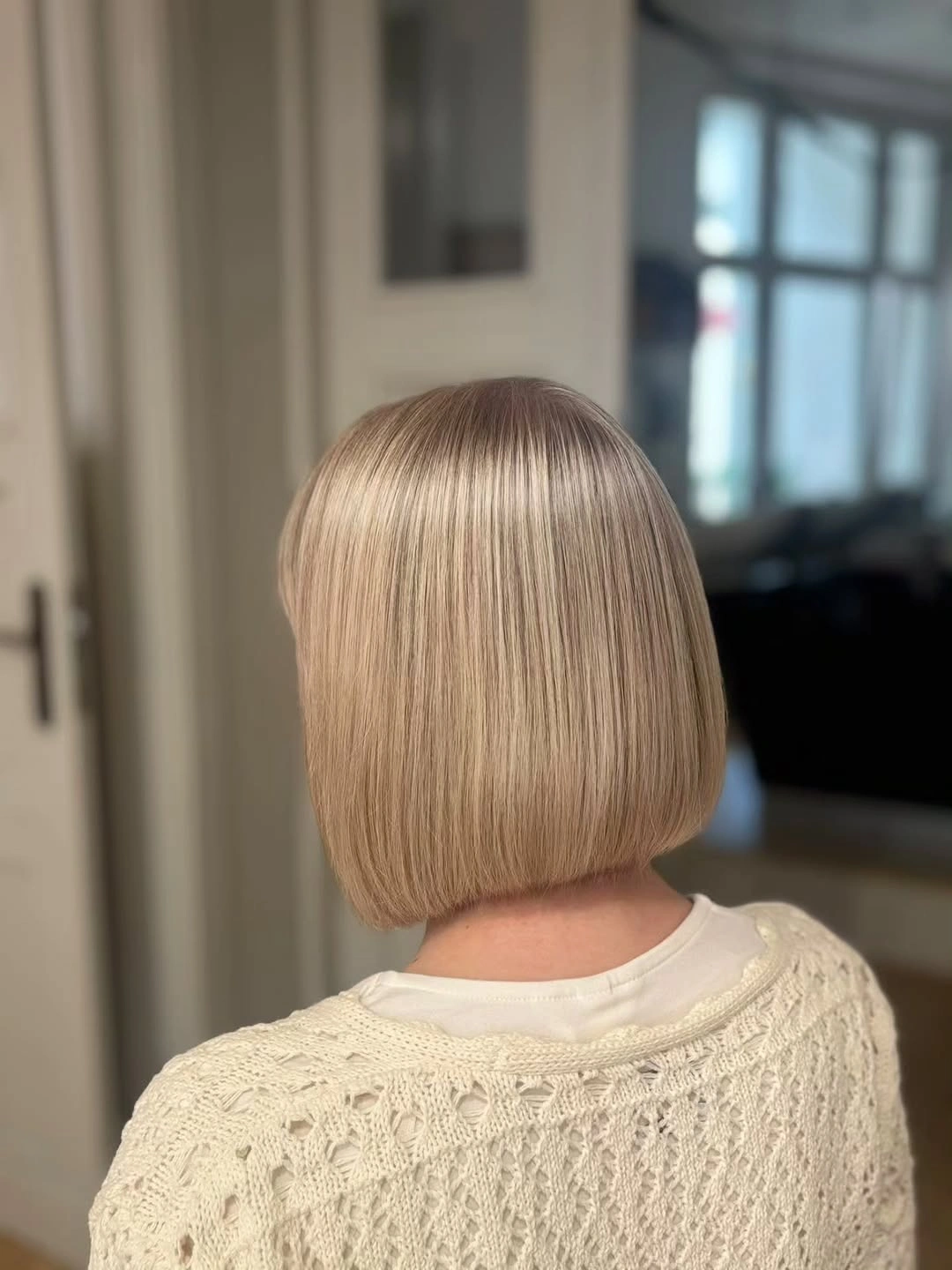 Short blunt beige blonde bob with softly deeper crown