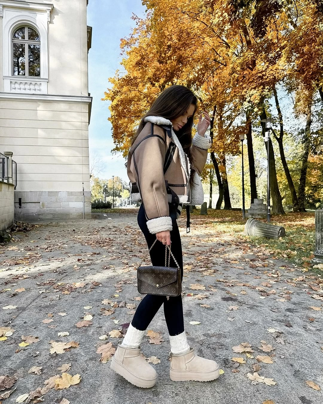 Beige trimmed jacket with black leggings and chunky cream boots