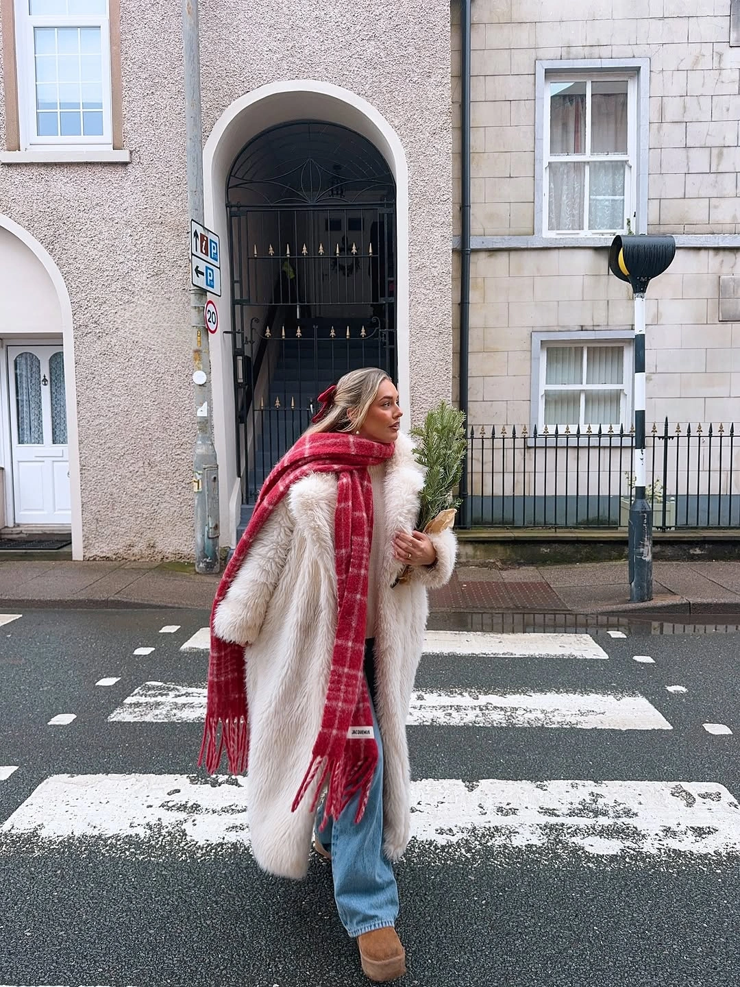 White shaggy coat with red plaid scarf and light jeans