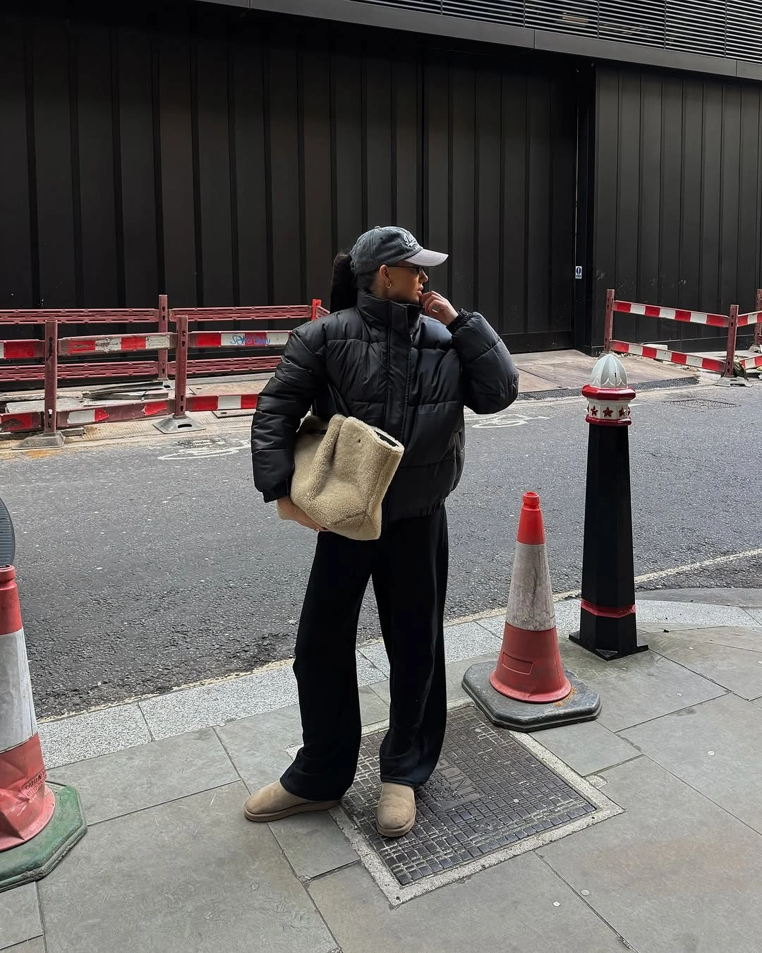 Black puffer with wide pants, tan boots and cream tote