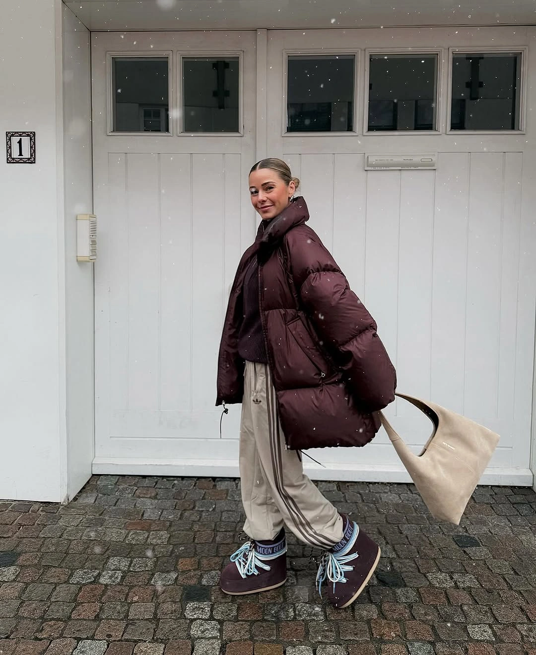 Burgundy puffer with beige drawstring pants and blue-laced footwear