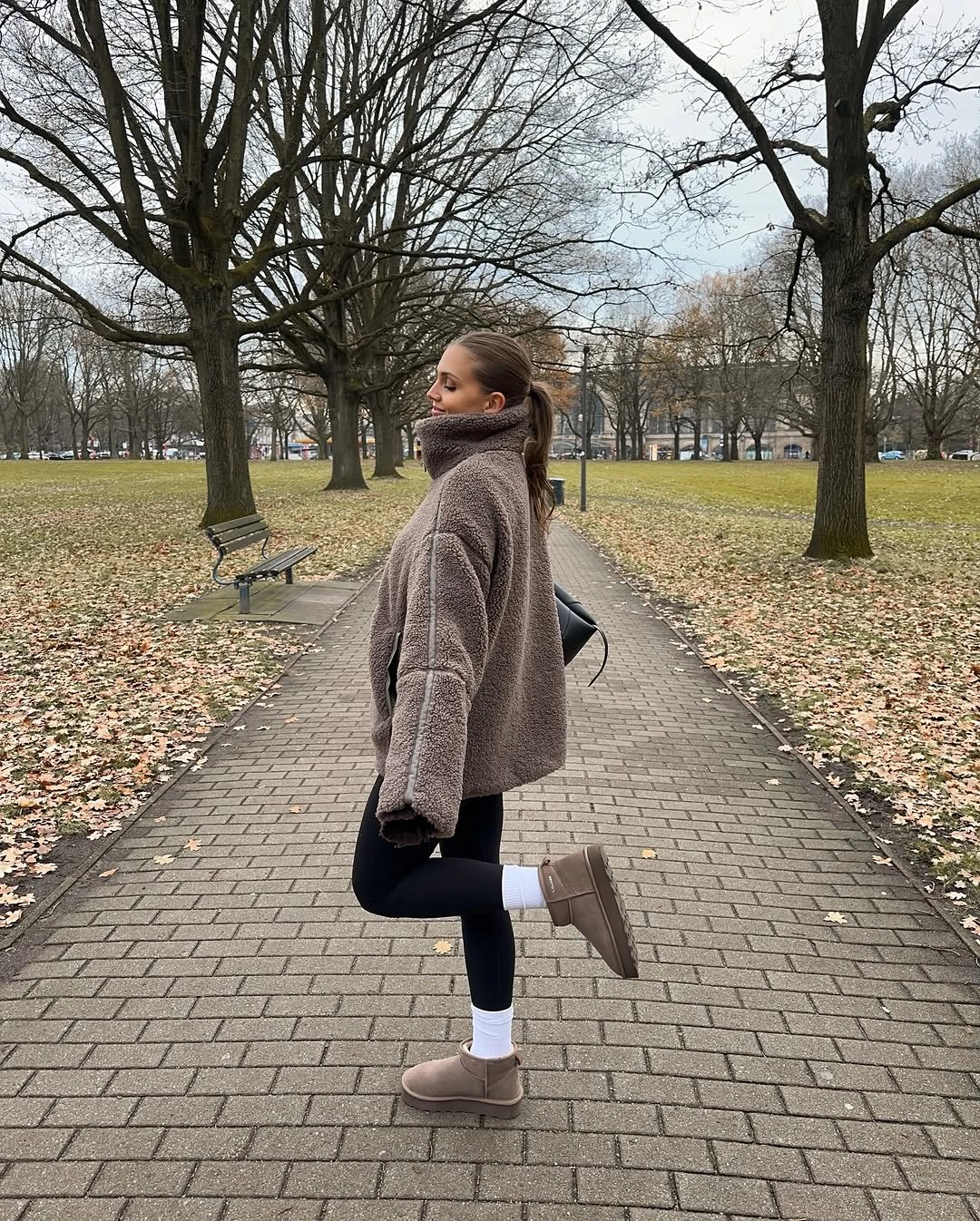 Taupe plush jacket with black leggings and tan platform boots