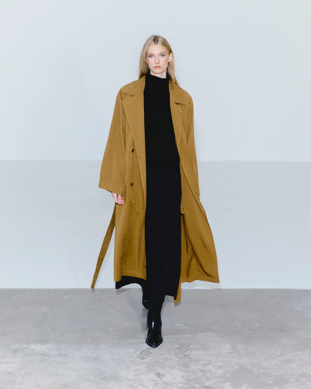 Mustard-camel long coat over black column and glossy tall boots