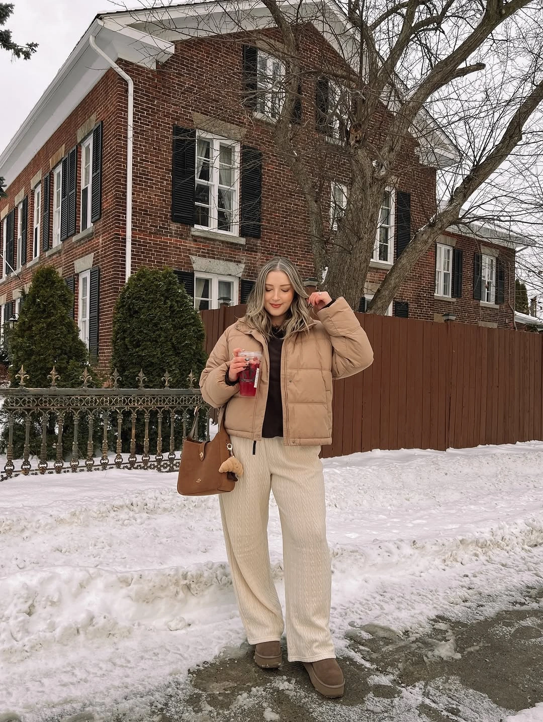 Cropped tan puffer-style jacket with cream wide pants and brown tote