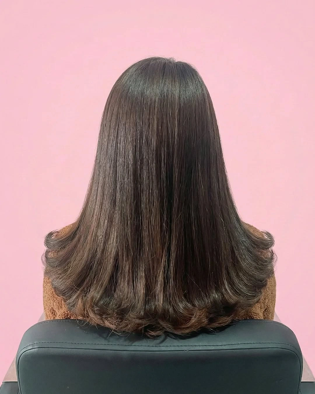 Shoulder-length dark hair with smooth top and flipped lower layers