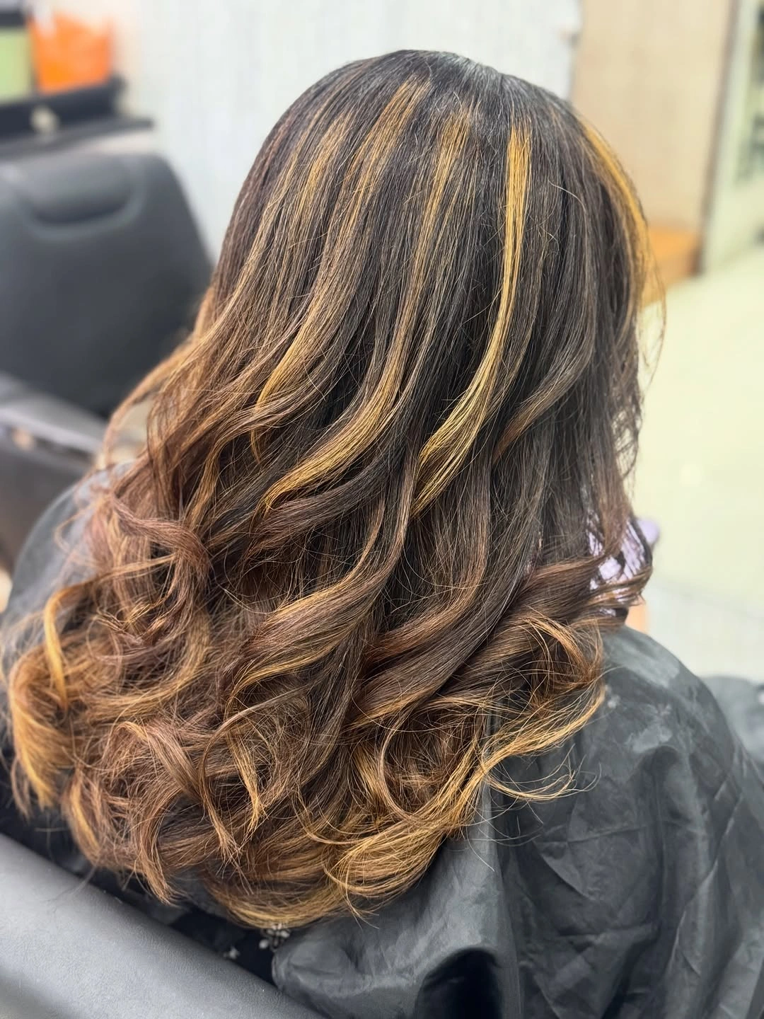 Long brown layered hair with loose waves and curved ends