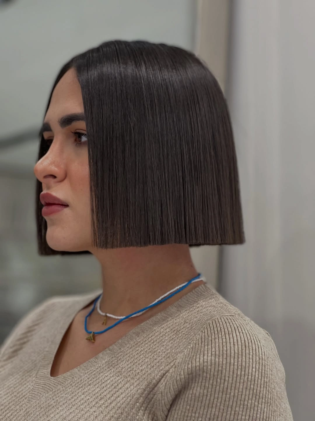 Straight dark chin-length bob with center part and blunt edge