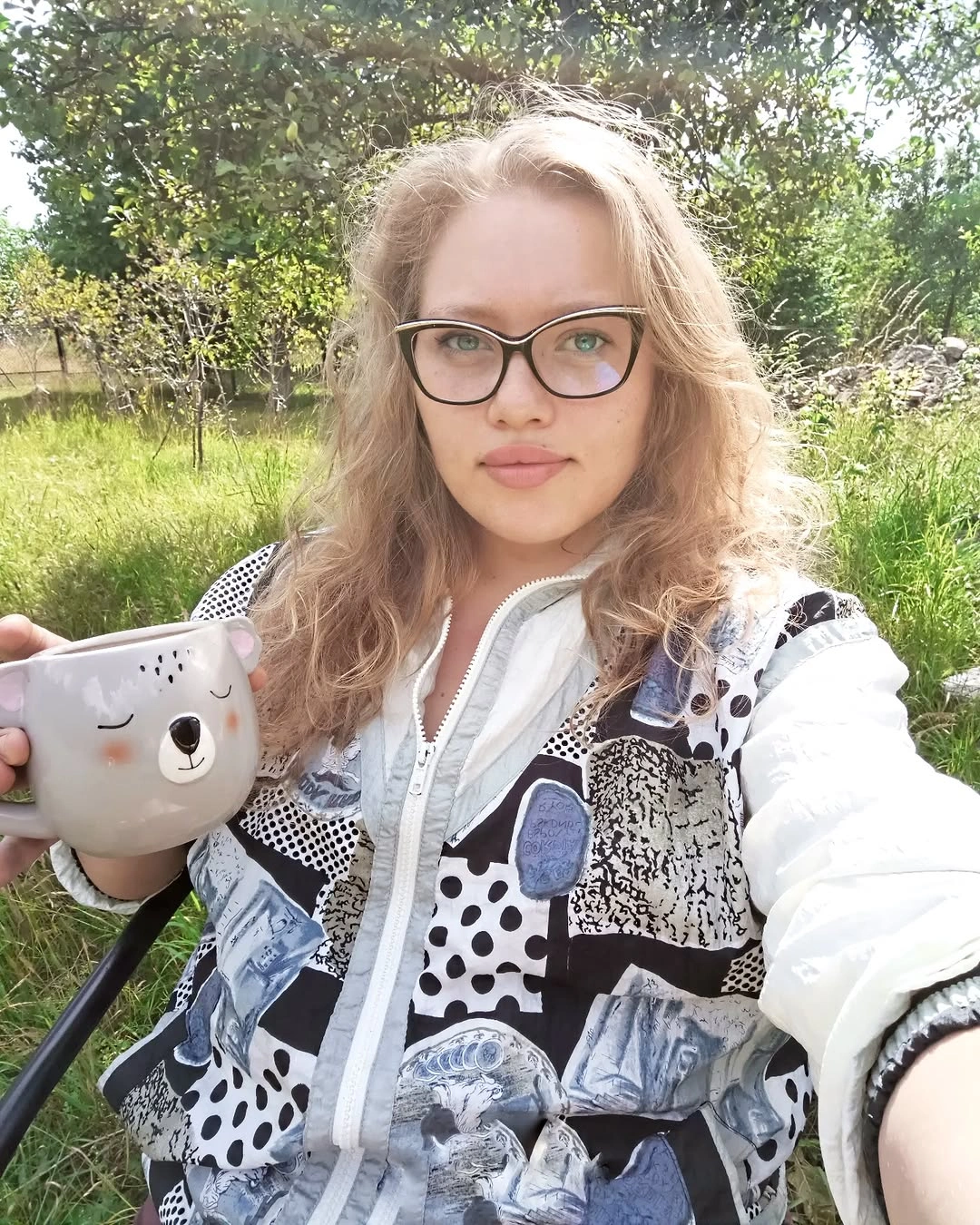 Long light hair with loose curls and dark-framed glasses