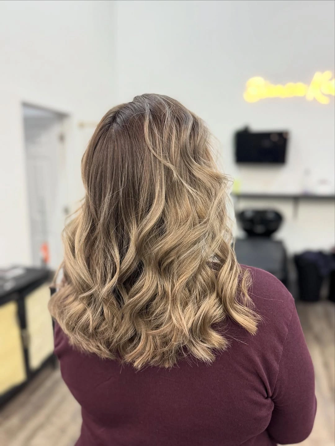 Shoulder-length highlighted hair with loose waves and darker roots