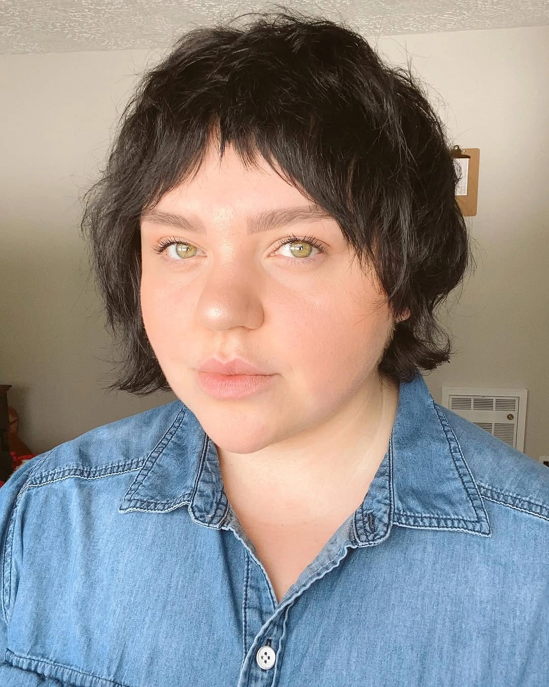 Short dark layered hair with choppy fringe and longer nape
