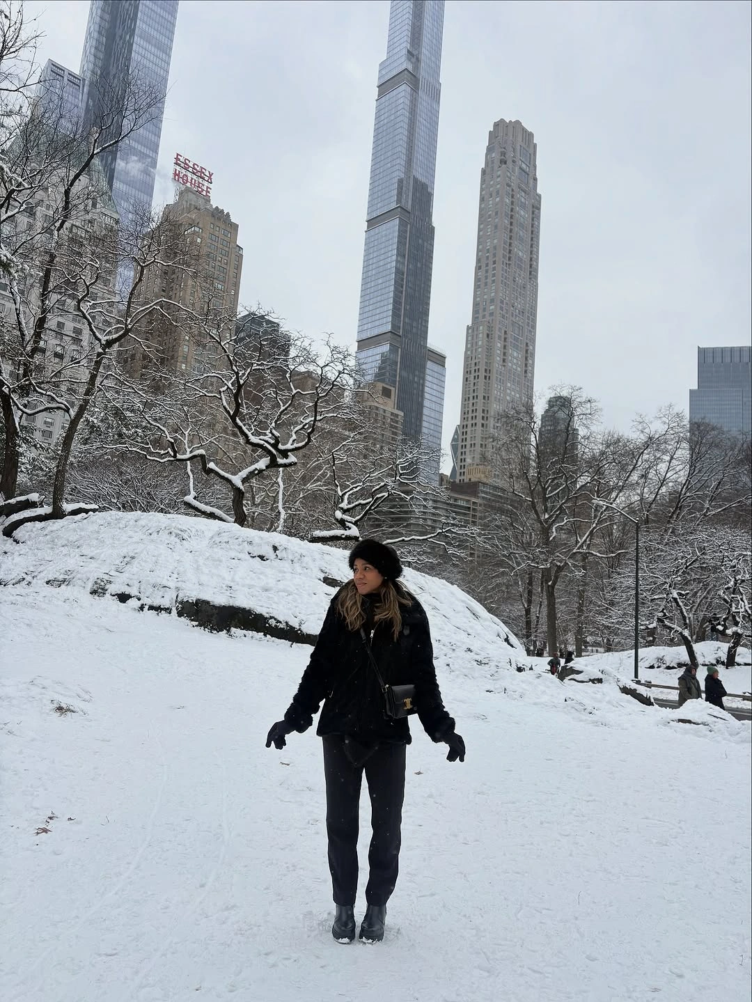 Short black jacket with dark pants in snowy park