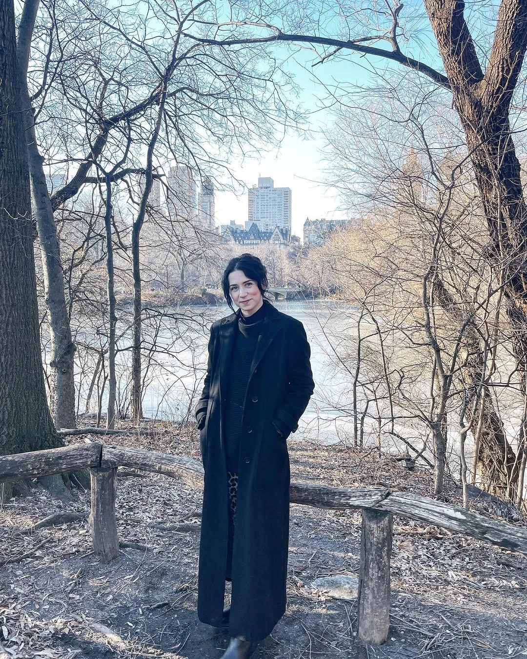 Ankle-length black tailored coat with dark high neckline