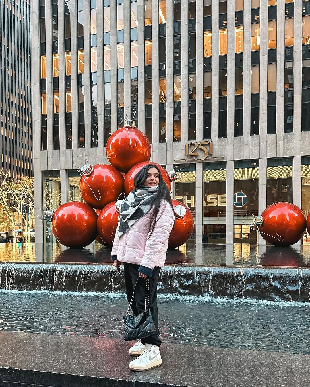 Pale pink puffer with patterned scarf and white sneakers