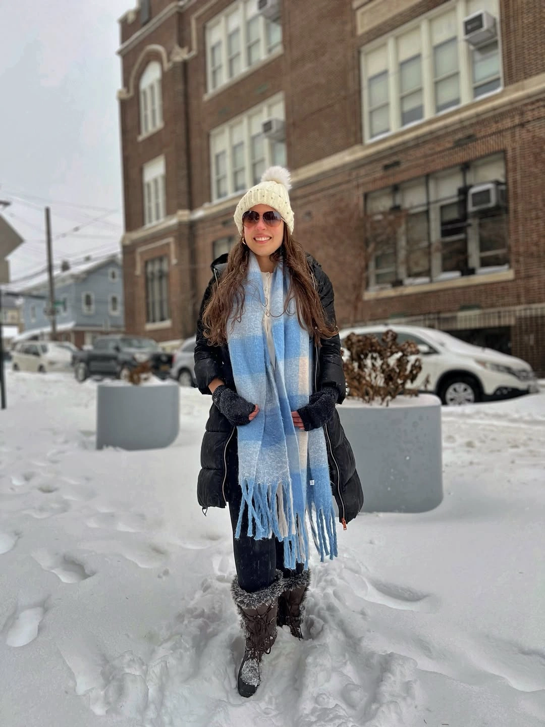 Black puffer with pale blue scarf in deep snow