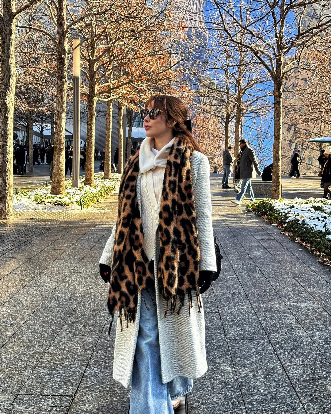 Long light coat with leopard scarf and relaxed blue jeans