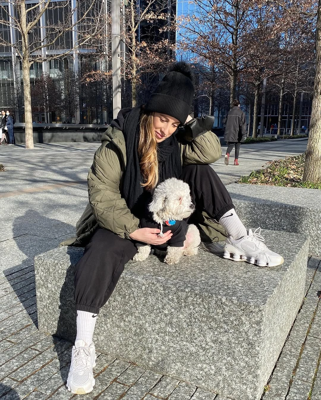 Olive padded jacket with black pants and white sneakers