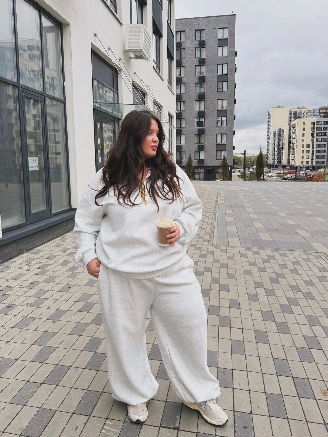 Cream sweatshirt and sweatpants with white sneakers outdoors