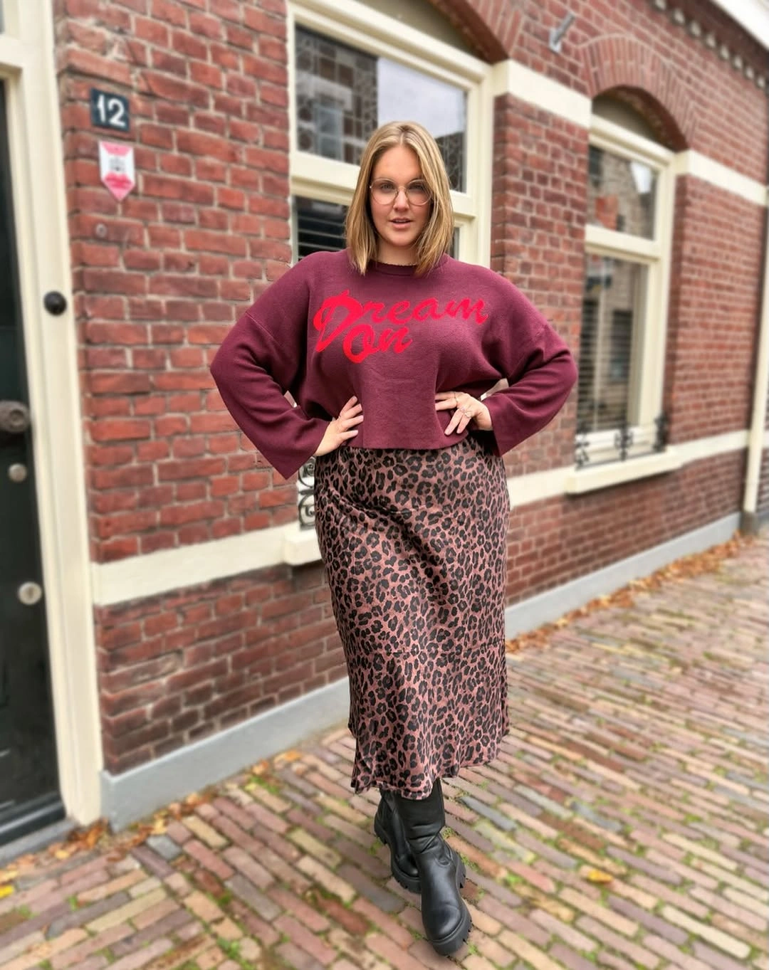 Burgundy graphic sweatshirt with leopard skirt and black boots