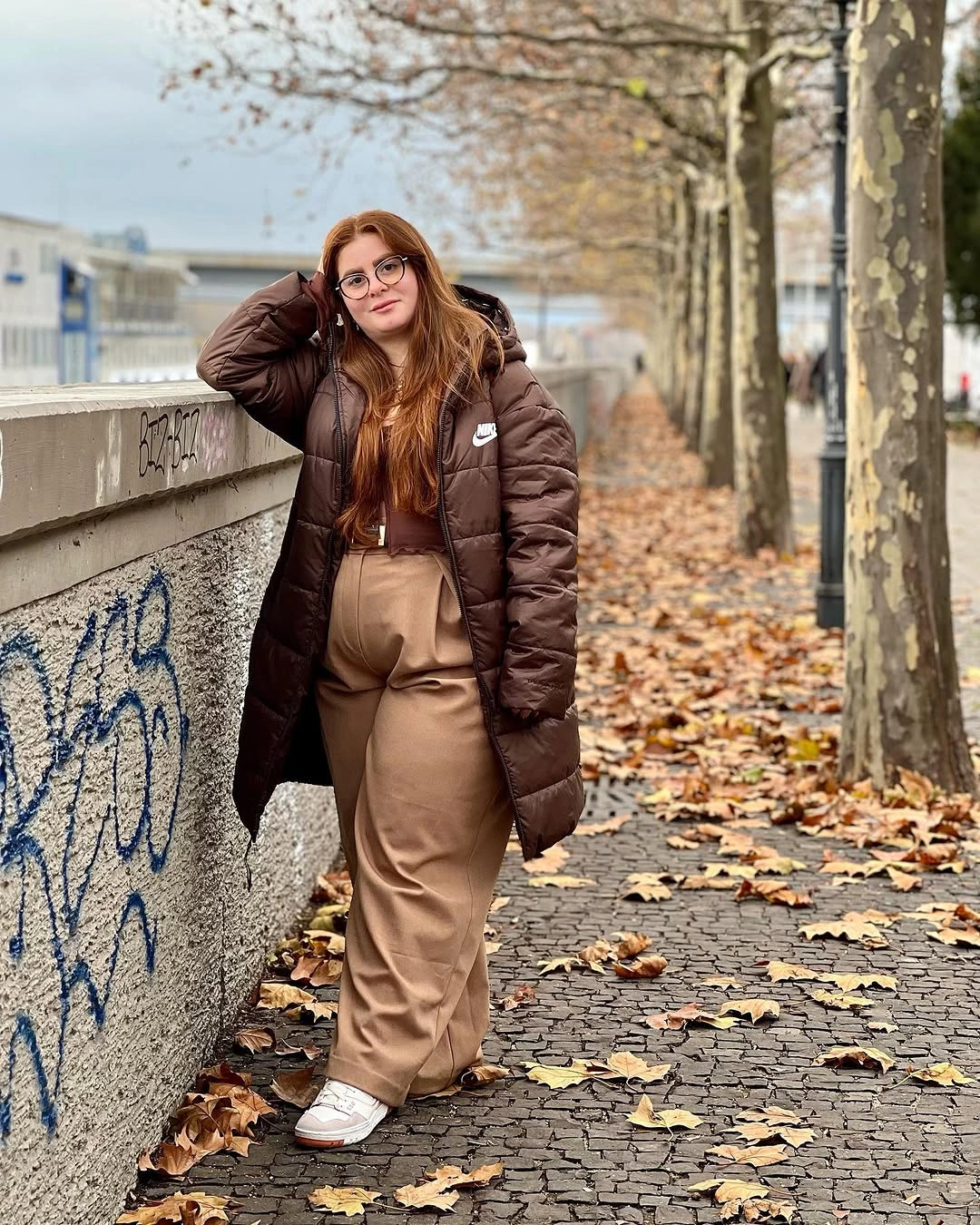 Brown puffer jacket with beige trousers and white sneakers