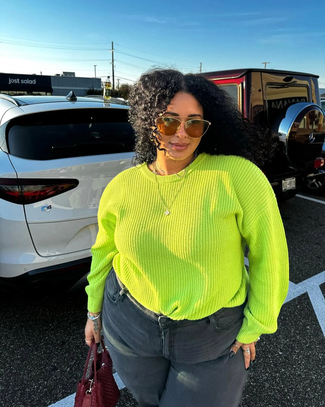 Bright lime ribbed sweater with dark jeans and sunglasses