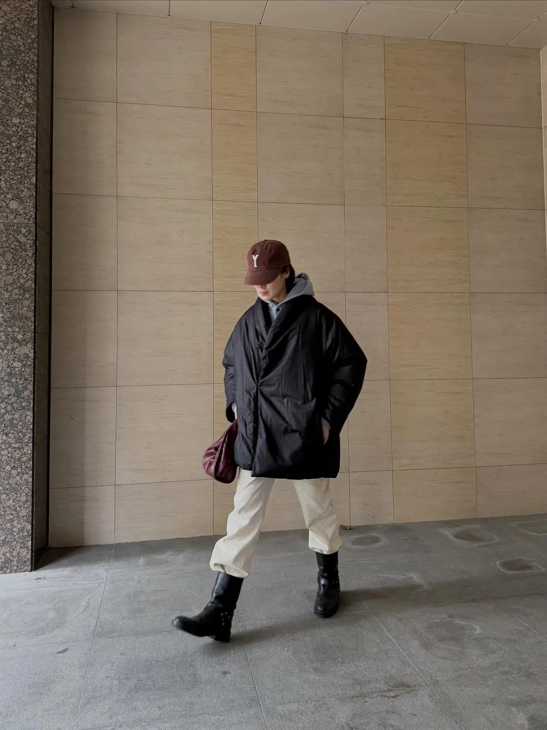 Long dark coat over black layers with white neckline