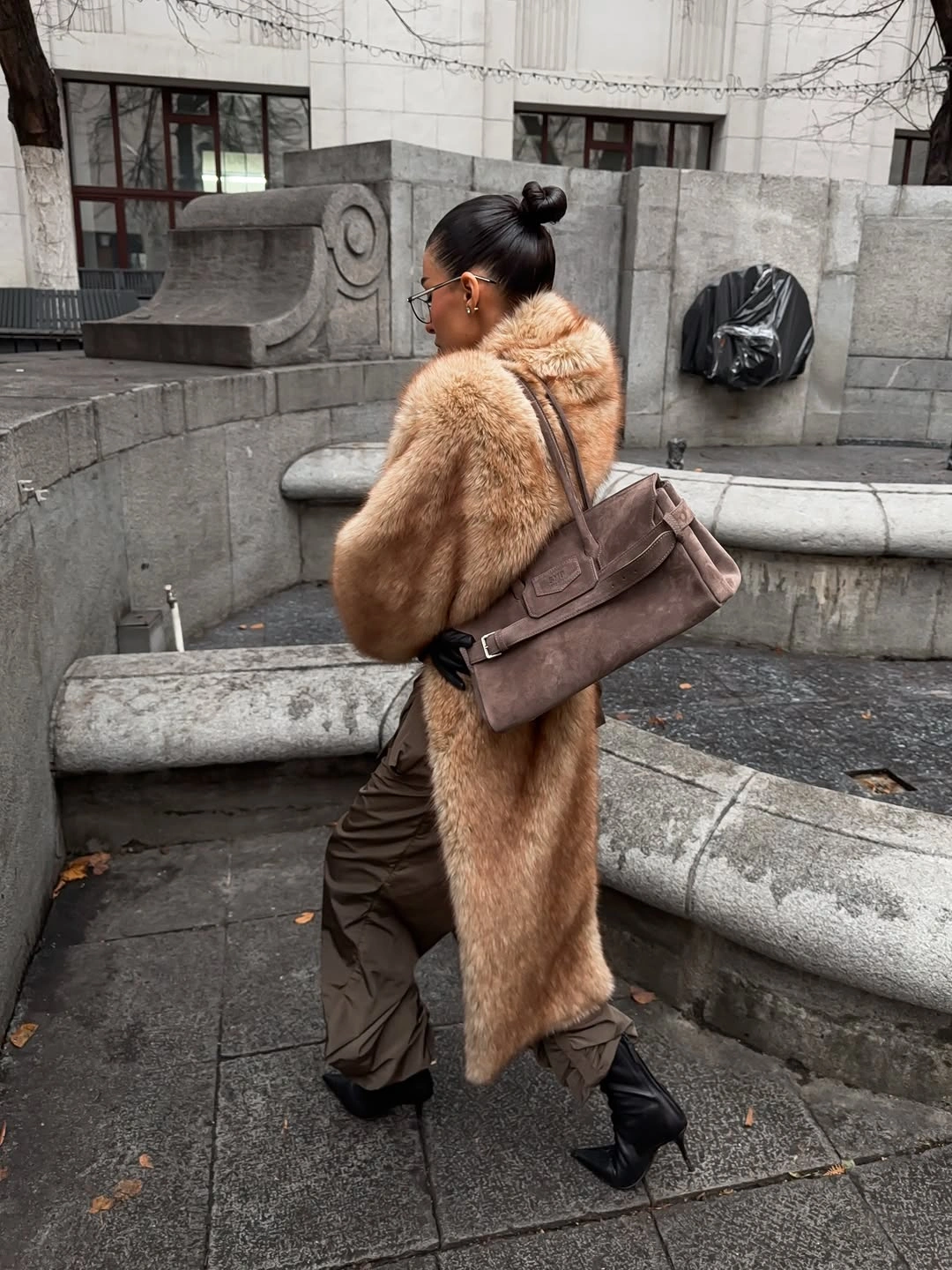 White fuzzy-looking jacket with headphones and dark wide pants