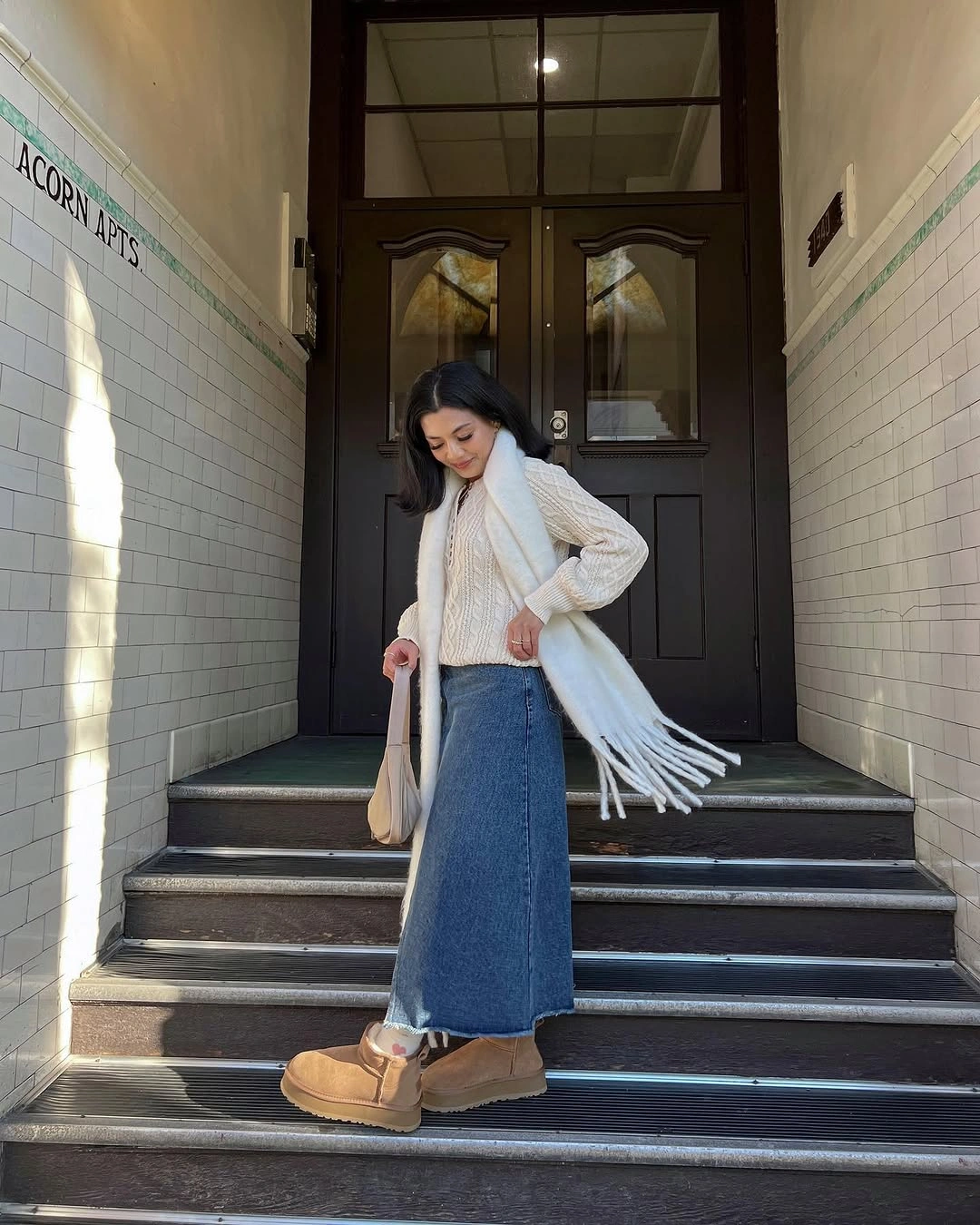 Cream knit layers with long denim skirt, scarf, and tan boots