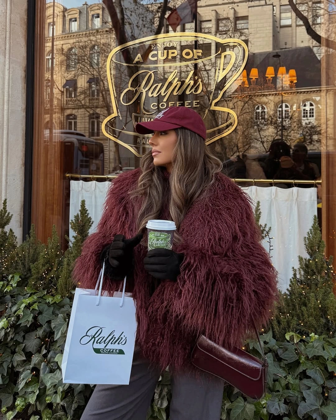 Deep burgundy shaggy coat with dark trousers, gloves, and cap