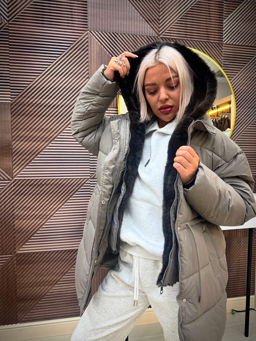 Gray puffer with dark trim over white hoodie and pants