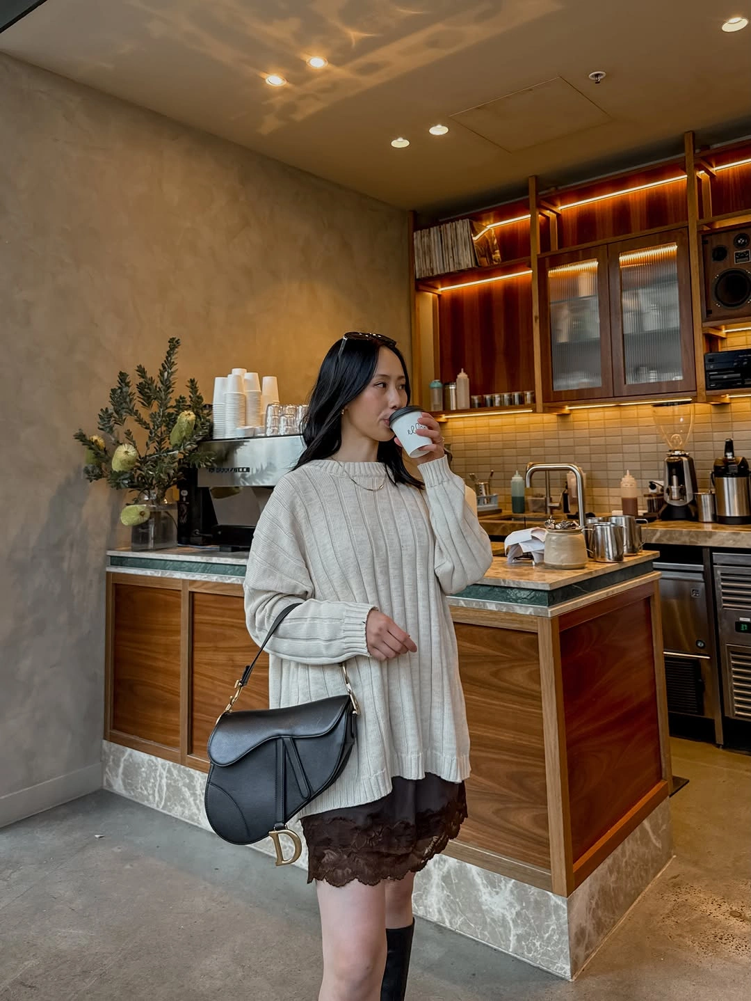 Oversized pale ribbed sweater with dark textured skirt and black bag