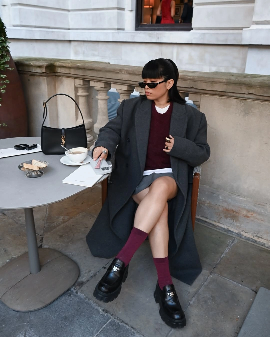 Charcoal coat with burgundy sweater, skirt, socks, and black loafers